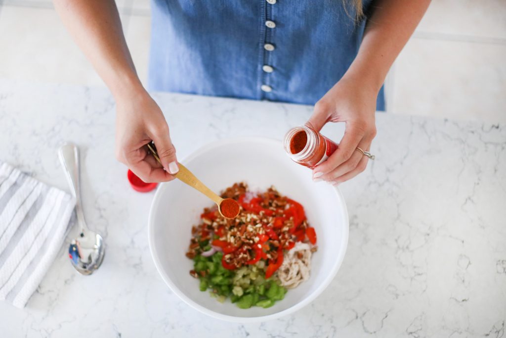Adding ingredients to spicy chicken salad